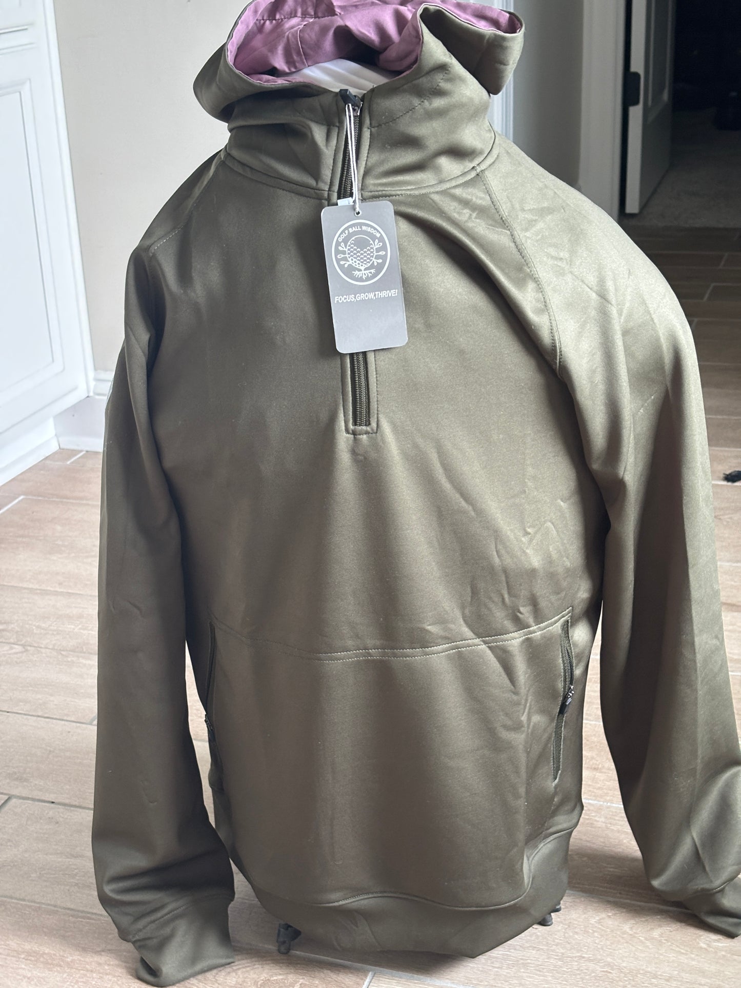 Army green performance hoodie with black half-zip and vertical pockets – Golf Ball Wisdom’s limited Ruck Hoodie supporting teen mentorship